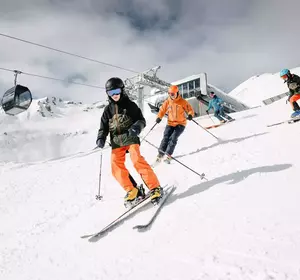 Skifahrer auf der Alpjoch-Abfahrt in Imst mit Gondeln im Hintergrund