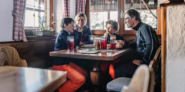 Familie beim Essen in der Latschenhütte Imst im Winter