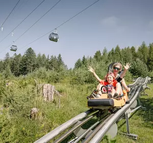Mutter und Kind beim Alpine Coaster fahren im Sommer in Hoch-Imst