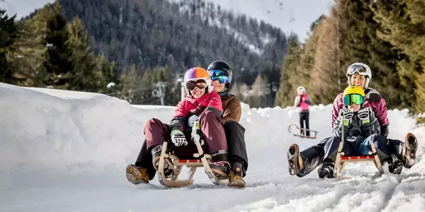 Familie beim Rodeln im Winter im Skigebiet Imst
